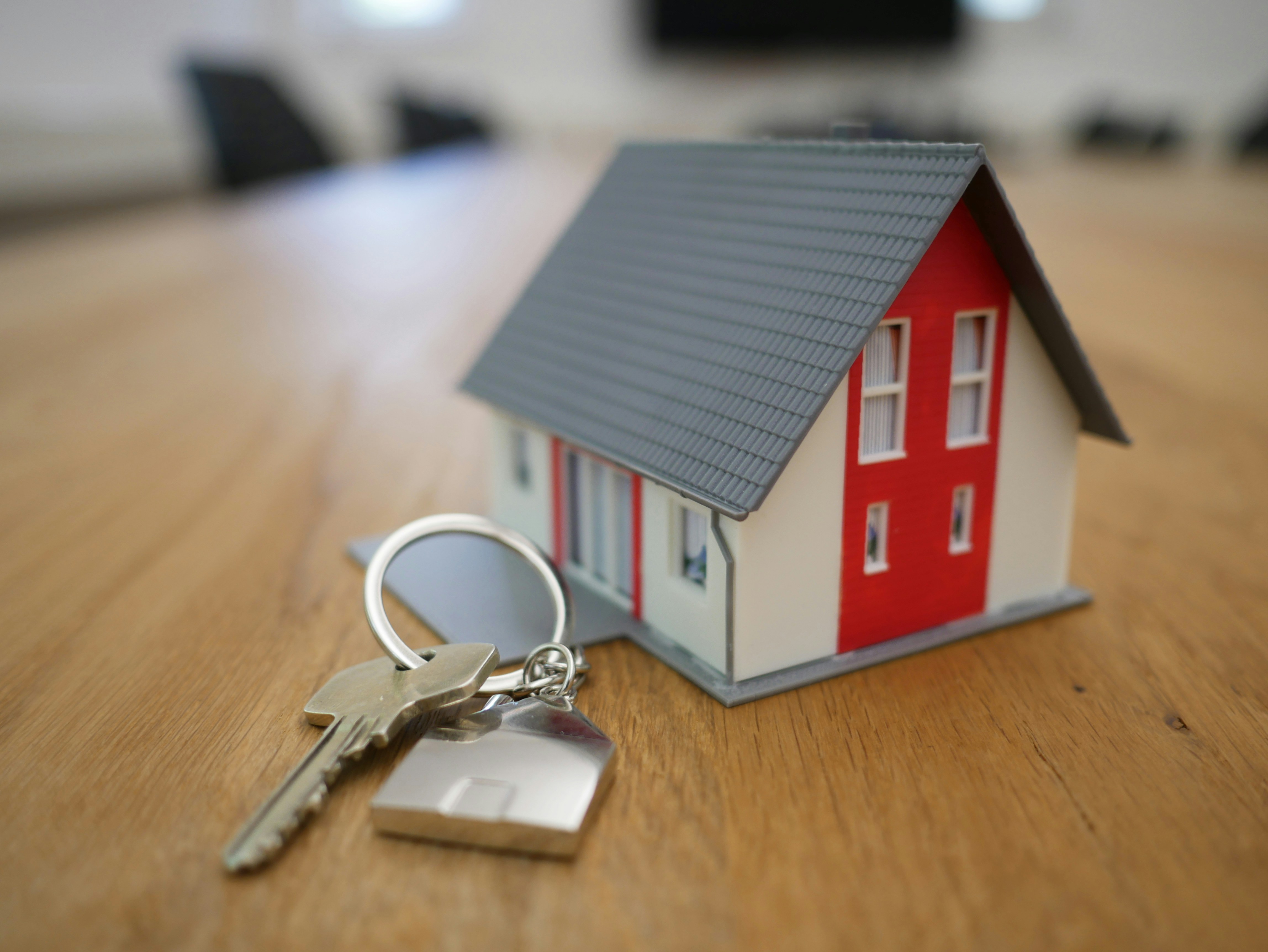 a miniature model of a new house with the house keys next to it laid out on a table