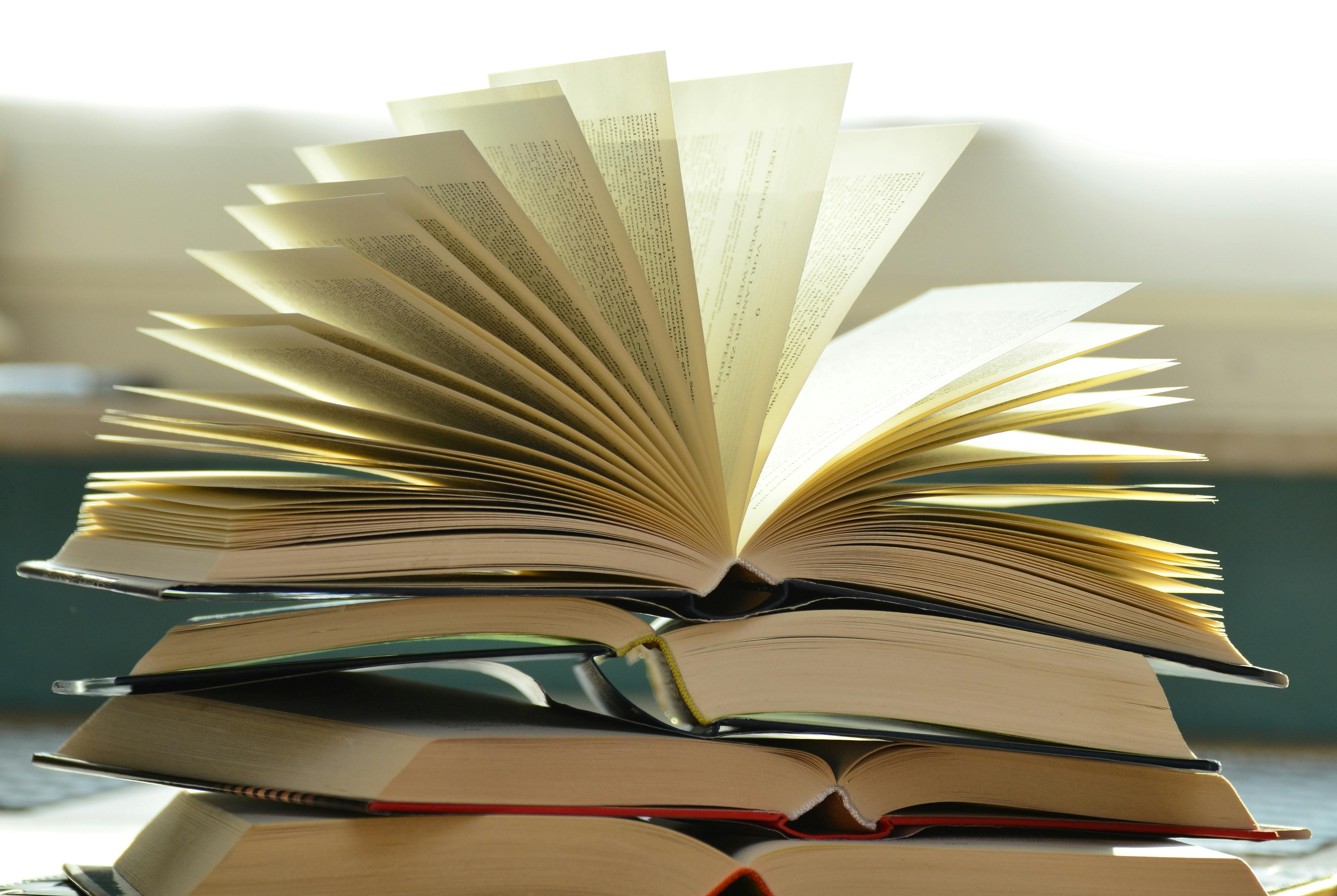 An open book on top of a pile of open books
