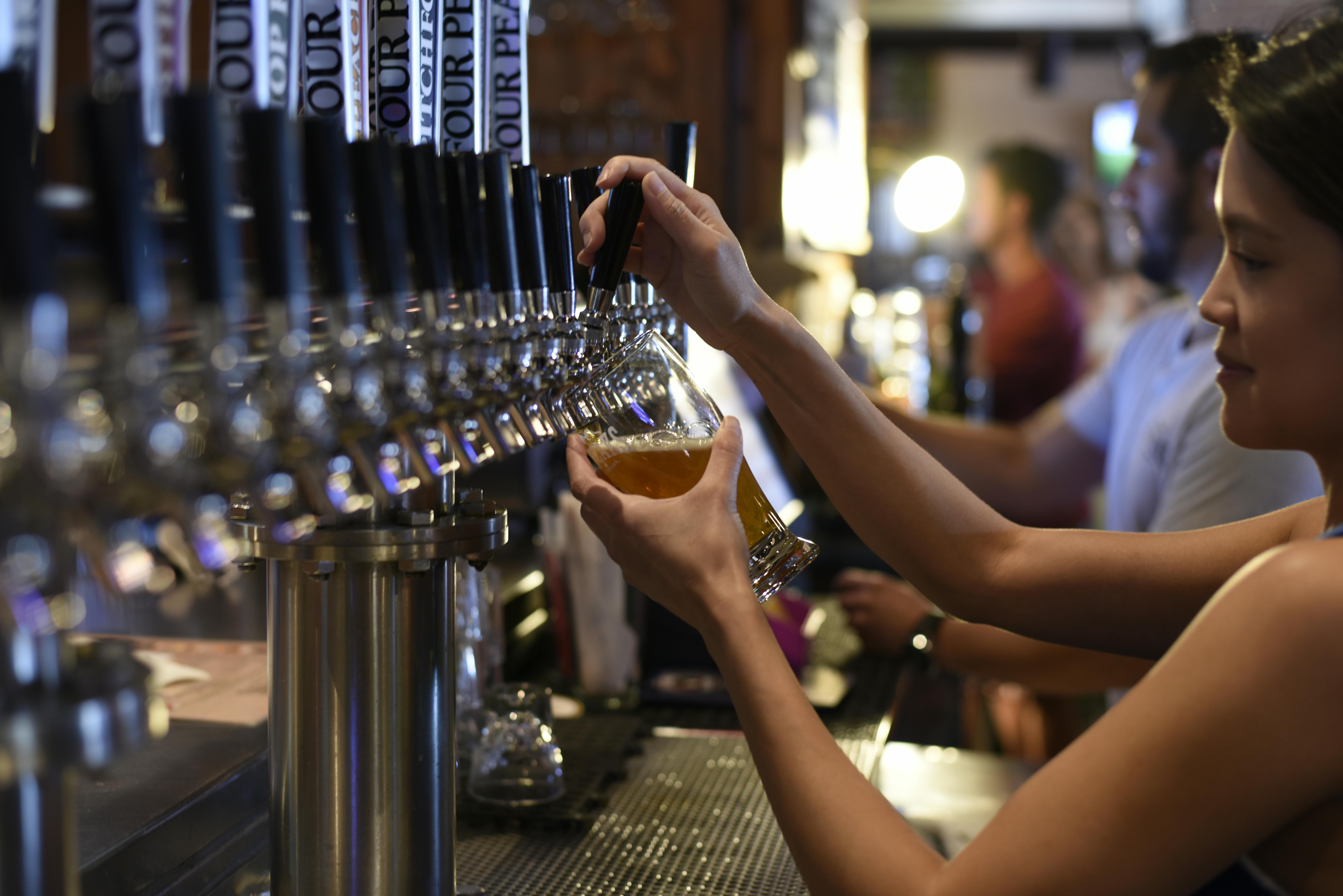 Bartender pouring a pint of beer in a pub