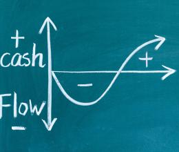 a chalkboard illustration showing incoming and outgoing cash flow as a graph going up and down