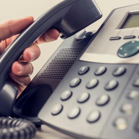 hand picking up telephone speaker
