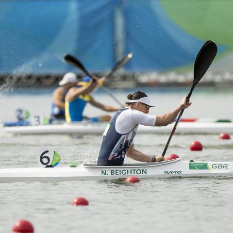 professional sports people rowing in water