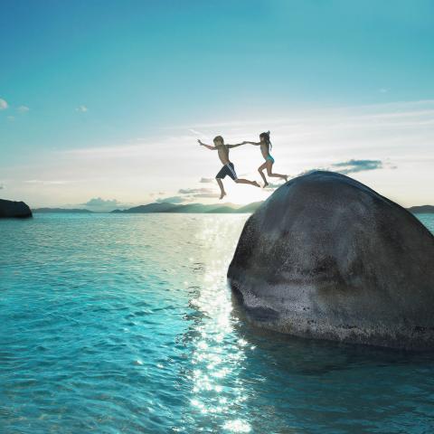 Children jumping into sea