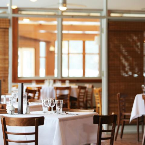 restaurant table that has been set with wine glasses 
