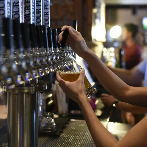 Bartender pouring a pint of beer in a pub