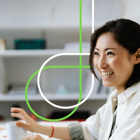 Smiling woman at a desk with a laptop
