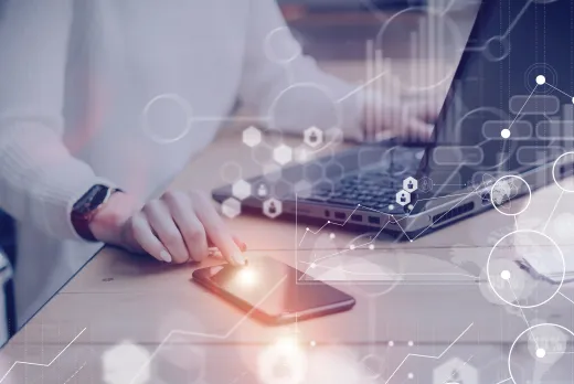 a visual photo of a person using their laptop and phone for work purposes, with graphics around them to represent cloud accounting