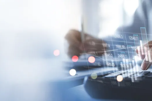 Businessperson using a calculator with pen and financial documents, overlaid with digital graphs and stock market data visuals, representing financial analysis or accounting work